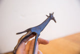 Vintage African giraffe sculpture held in hand showing its textured surface and dark patina.