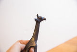 Low-angle view of the vintage African giraffe's head showing its dark, textured patina.