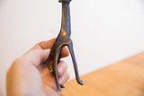 Hand holding vintage African giraffe sculpture, showing textured patina and scale.