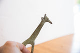 Vintage African giraffe sculpture with textured body and time-softened green-brown tones.