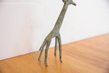 Vintage African giraffe sculpture's legs with green patina and textured finish.