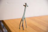 The slender form and oxidized green patina of a vintage giraffe sculpture.