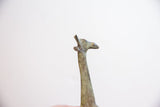 Profile detail of the vintage giraffe's head showing its oxidized, textured patina.