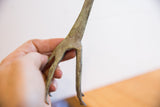A close-up view of the handmade details and oxidized patina on the giraffe's legs.