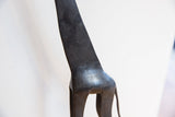 Hand-carved patterns and dark patina on the neck of a vintage African giraffe figure.