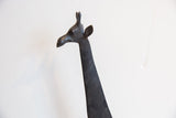 Profile of the vintage African giraffe's carved head and dark patina.