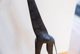 Hand-carved textured spots and dark patina on the back of a vintage African giraffe figure.