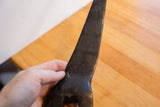 Hand holding the dark African giraffe figure showcasing its carved surface patina.
