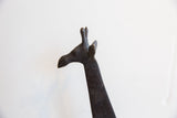 Profile view of the vintage giraffe's head showing its carved form and dark patina.