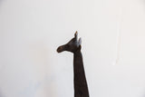 A detailed profile of the vintage carved giraffe's head showing its dark patina.