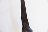 Close-up of the vintage giraffe's dark, textured patina and subtle carved patterns.