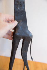 Hand-carved patterns and aged dark patina on the back of a vintage giraffe collectible.