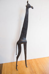 Angled view of the vintage African giraffe, highlighting its slender profile and dark patina.