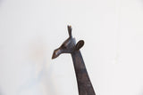 Profile of the vintage African giraffe sculpture's head showing its details and dark patina.