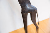 Dark textured patina on the sculpted haunches and tail of a vintage African giraffe figure.