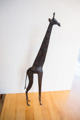 Vintage African giraffe sculpture showing its elongated form and dark patina.