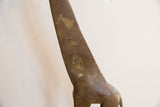 Detailed view of the etched patterns and aged patina on the vintage giraffe's neck.