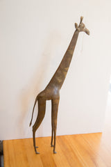 Side profile of a vintage African giraffe collectible showing its slender form and aged patina.