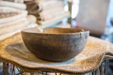 Detail of vintage African wooden bowl showing weathered wood exterior and metal rim repair.