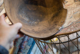 Textured dark interior of vintage African wooden bowl, showing cracks and repair.