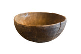 Vintage handmade African wooden bowl with a dark rustic patina and visible character cracks.