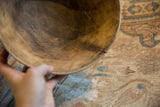 Vintage African wooden bowl, close-up of its textured interior and unique rim crack.
