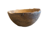 Handmade vintage African wooden bowl with incised geometric patterns and rich brown aged texture.