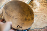 Vintage African wooden bowl interior close-up, showing cracks and metal repairs.