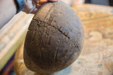 Close-up detail of the vintage African wooden bowl's storied cracks, metal repairs, and carved patterns.
