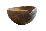 Vintage African wooden bowl with a dark rustic patina, hand-carved patterns, and aged imperfections.
