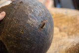Weathered cracks and a chip on the dark, rustic surface of the handmade bowl.