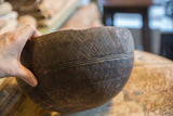 A hand holding the vintage wooden bowl, showing its scale and hand-carved texture.
