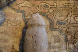 Detailed view of the weathered, pitted surface of the antique Neolithic stone tool.