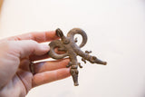 Vintage African double crocodile pendant held in hand to show its scale and textured patina.