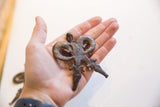 Vintage double crocodile pendant held in hand, showing its textured surface and scale.