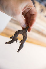 Dark, weathered texture of the vintage African crocodile pendant held in hand.
