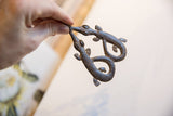 Vintage African double crocodile pendant held in hand to show its scale and textured surface.