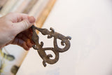 In-hand view of the vintage African double crocodile pendant's weathered metal surface.