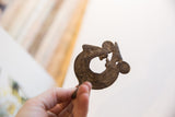 Vintage lizard pendant held in hand to show its scale and aged patina.