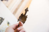 View of the vintage turtle pendant's concave interior and dark aged patina.