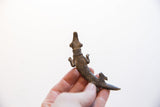 Vintage African crocodile pendant held in hand, revealing its textured surface and form.