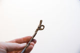 Detail of the cast loop and aged metal texture on the vintage crocodile pendant.