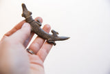 Angled view of the vintage crocodile pendant highlighting its textured body.