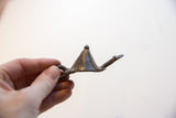 Angled view of the vintage African turtle pendant showing its textured metal form.