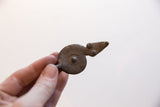 Vintage African snake pendant held to scale, detailing its aged patina and textured surface.