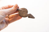 Vintage African snake pendant held to show its scale and rustic, coiled body.