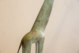 Etched surface patterns and mottled green patina on the vintage African giraffe figurine.