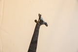 Detailed profile of the vintage giraffe's head showing its carved texture and dark patina.