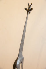 Low angle view of the vintage African giraffe sculpture's textured neck and head.