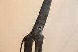 Pitted surface detail and dark, aged patina on the vintage giraffe's neck.
